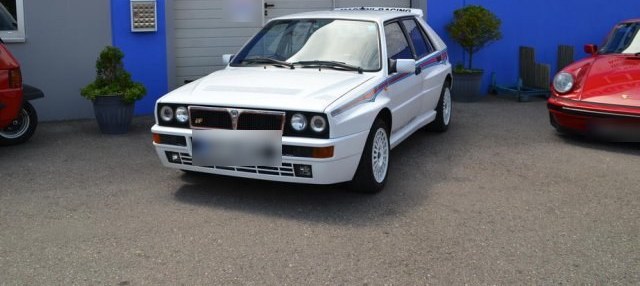 Weißer Lancia Delta Integrale vor der Werkstatt