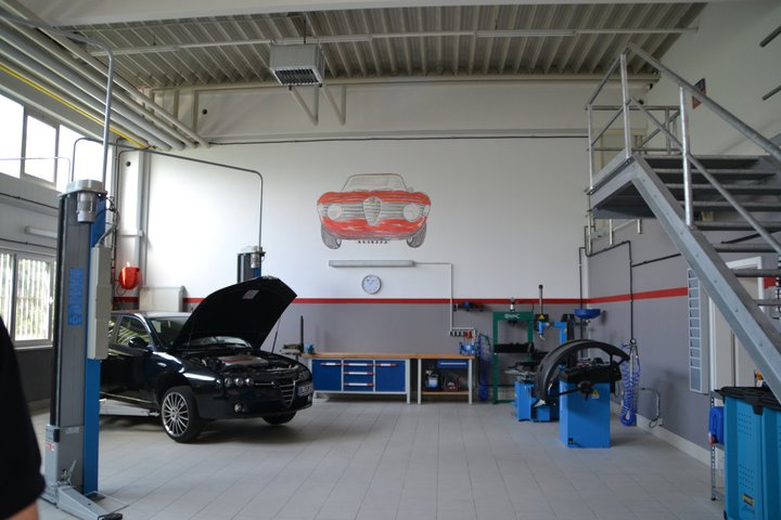Werkstatthalle von Automania Marasco mit Hebebühne und Alfa-Romeo-Wandbild